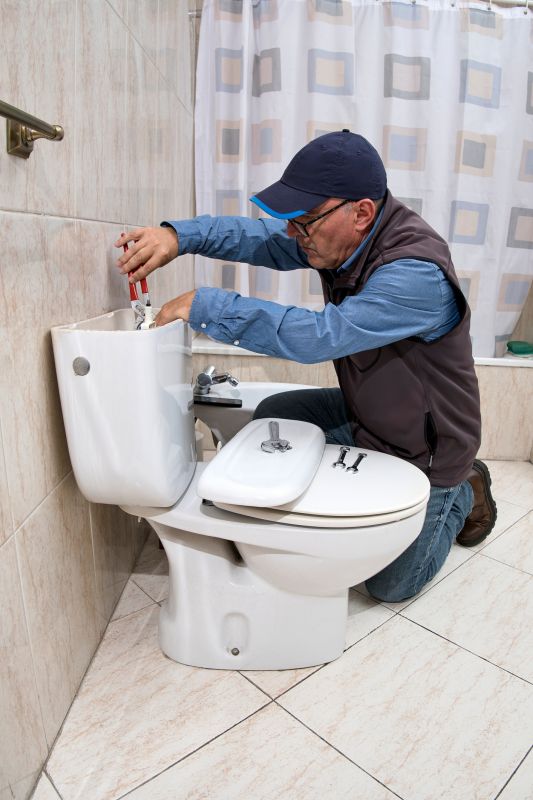 Plumber Repairing a Toilet